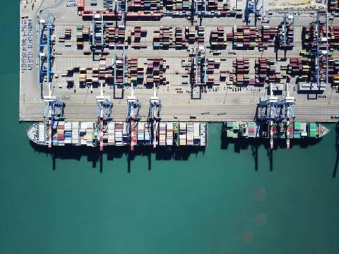 Fully loaded container ships docked at freight port terminal Stock Photos