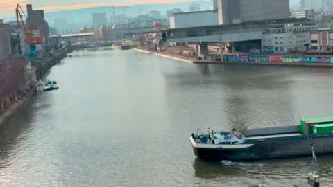 A fully loaded long container riverboat sails across a harbor basin in Basel Видео 331297129