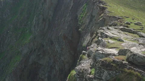 Fulmars fly next to the cliffs below 'The Gap' on Hirta, St Kilda, Scotland Stock Footage 229475069