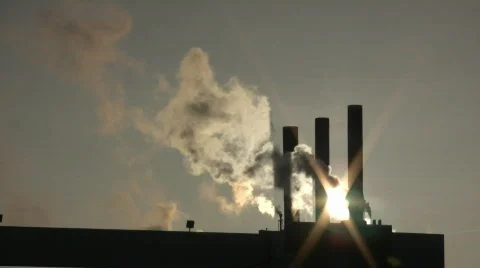 Fumes billow from giant chimney amidt the sunlight (High Definition) Stock Footage