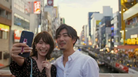 Fun 20's couple taking seflies while traveling in Osaka Japan attractions at  Vidéo 111542379