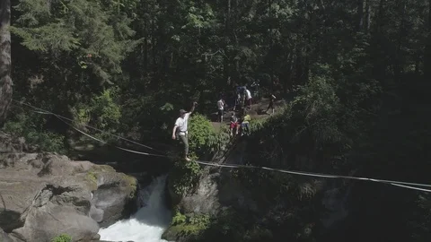 Fun Aerial View of Slackliner by Running Waterfall (flat cine profile) Stock-Footage 81844561