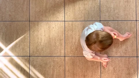Fun child sitting on the floor and turning clockwise around youself, the view Stock Footage 144397385
