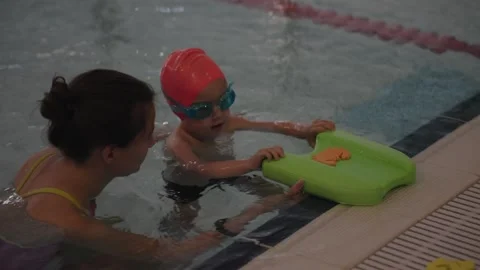 A fun Child Swimming Lesson led by a qualified Instructor at the Pool is a great Stock Footage 312435192