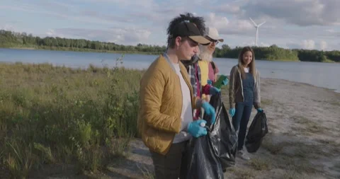Fun Cleanup: Joyful Multiracial Team Fighting Pollution Stock Footage 256025080
