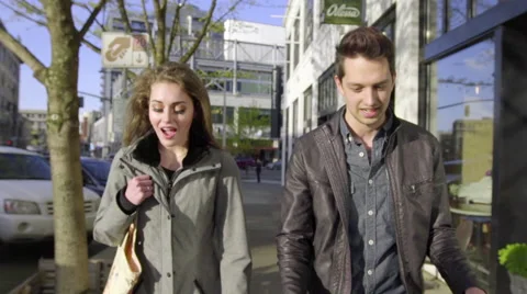 Fun couple laugh as they chat and walk Stock Footage 61626562