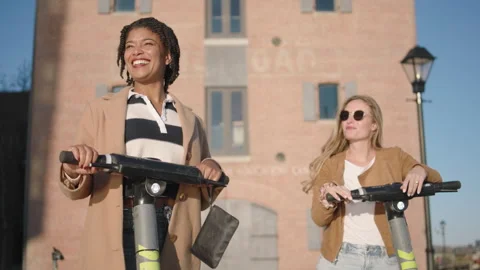Fun day out on electric scooters with friends by the boardwalk Stock Footage 319918529