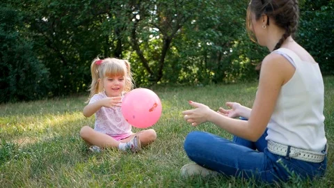 A fun game with the ball in the Park. A young woman and a child. Video stock 95494827