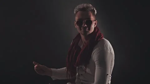 Fun man in a red scarf on a dark background Stock Footage 121817887