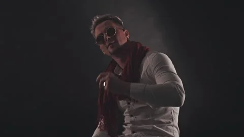 Fun man in a red scarf on a dark background Stock Footage 121817937