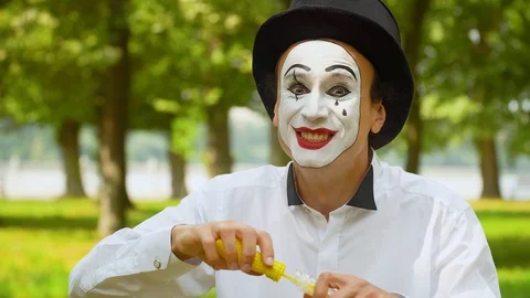 Fun mime blowing soap bubbles outdoors Video stock 116174712