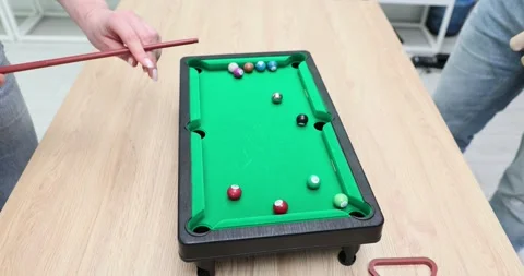Fun miniature billiards competition game between friends in a cozy indoor Video stock 296674861