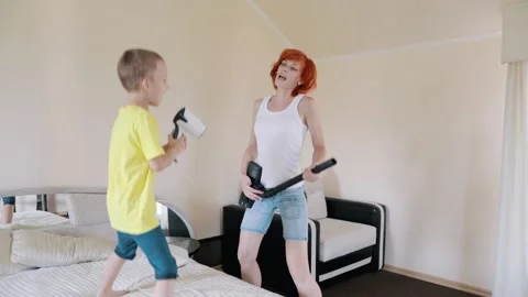Fun Mom and son sing and dance. The red-haired girl imitates playing the guitar, Stock Footage 156300981