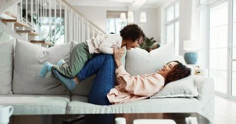 Fun, mom or kid on sofa with lifting, happy relationship or bonding together for Stock Photos