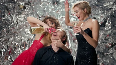 Fun Party. Three Young People On Shiny Background. Girl Pours Champagne Into His Stock Footage 178590983