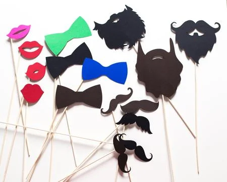 Fun photo booth props featuring colorful mustaches, lips, and bow ties for a Stock Photos