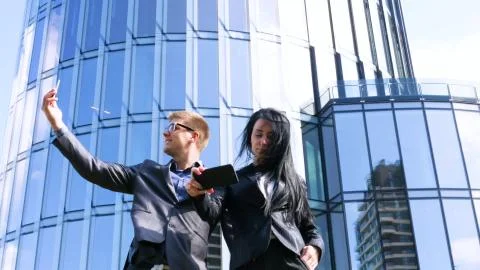 Fun Young Couple Taking Selfie With Mobile Phone on skyscraper background. Stock Photos