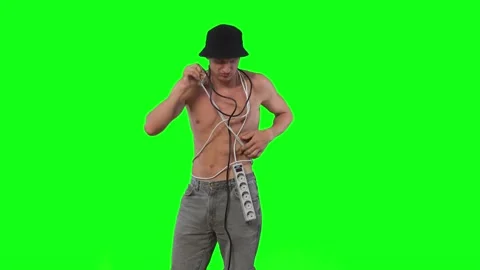 Fun young guy got tangled in extension cords and tries to get out green screen Vidéo 239666066