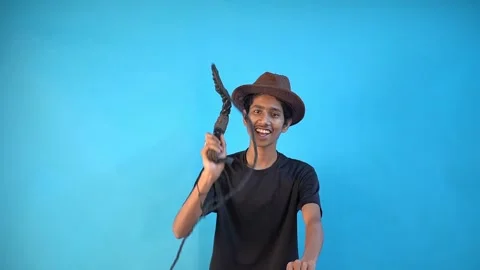 Fun young Indian boy in basic black t-shirt isolated on blue background Stock Footage 163826501