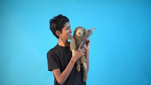 Fun young Indian boy in basic black t-shirt isolated on blue background Stock Footage 163826565