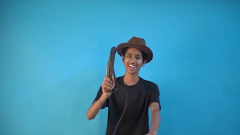 Fun young Indian boy in basic black t-shirt isolated on blue background Stock Footage 164500446