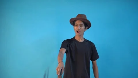 Fun young Indian boy in basic black t-shirt isolated on blue background Stock Footage 164523773