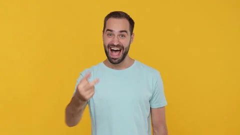 Fun young man 20s in basic casual blue t-shirt isolated on yellow background Stock Footage 148286235