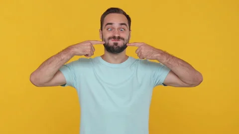 Fun young man in basic casual blue t-shirt isolated on yellow background studio. Stock Footage 148282631