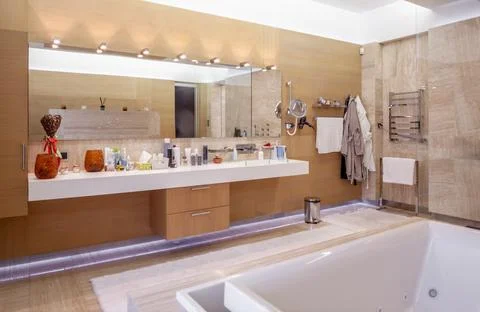 Functional bathroom with mirror with LED lighting and countertop for cosmetics Stock Photos