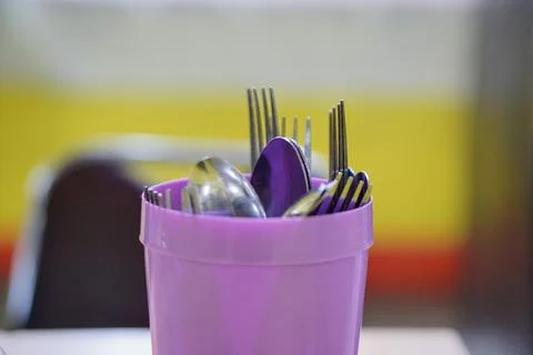 A functional purple plastic fork and spoon holder for everyday use in a home 스톡 사진