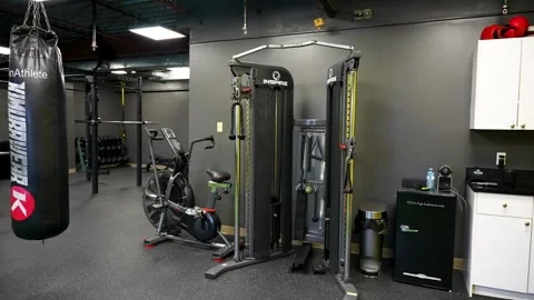 Functional training cable machine and air bike inside modern studio gym Stock Footage 330620666