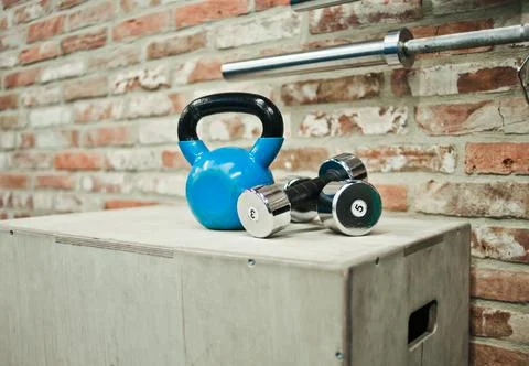 Functional training concept. Kettlebell, dumbbell stand on wooden box against Foto stock