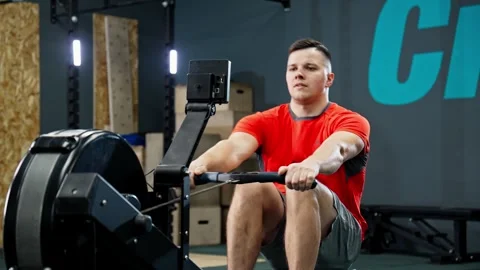 Functional training. Sportsman training with rowing machine in modern gym. Stock Footage 274389151