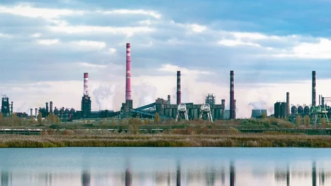 A functioning industrial plant with smoking pipes opposite river Video stock 118328800