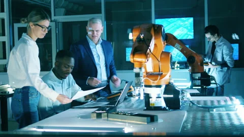 Functioning robotic arm with engineering team observing it Stock Footage 159807618