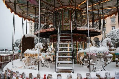 Functioning small carousel covered in snow Stock Photos