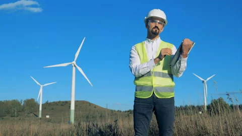 Functioning wind turbines with an energetics expert working near them Video stock 97985932