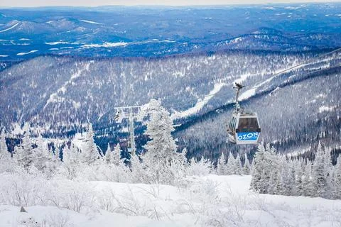 Funicular against the backdrop of a mountain forest, a cabin lifts athletes u Stock Photos