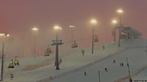 Funiculars are moving on the ski slope in the evening, its snowing, snow Stock Footage 327454607