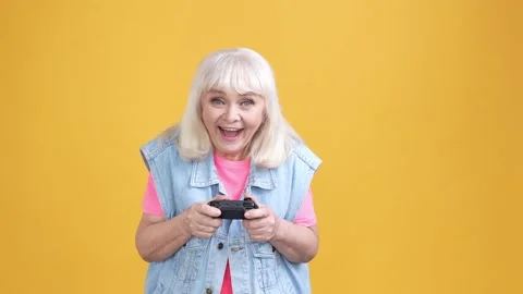 Funky aged lady playing video game fist up win isolated shine color background Stock Footage 189843590