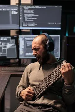 Funky developer singing at air guitar keyboard 스톡 사진