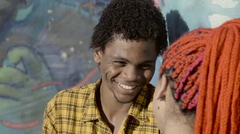 A funky young couple talking to each other near wall Stock Footage 61292308