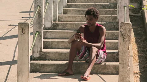 Funky young man sitting on steps and using his phone Stock Footage 61273685