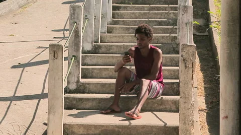 Funky young man sitting on steps and using his phone Stock Footage 61273686