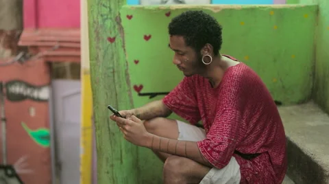 Funky young man typing a message on his mobile phone Stock Footage 61273644