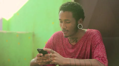 Funky young man typing a message on his mobile phone Stock Footage 61273648