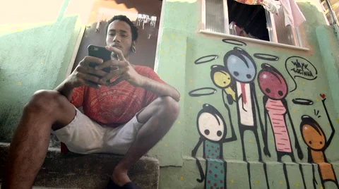 Funky young man typing a message on his mobile phone Stock Footage 61292346