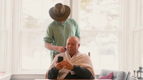 A funny 4K video of  son cutting hid dad's hair at home during quarantine. Stock Footage 149694849