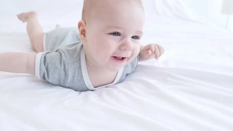Funny adorable kid infant boy playing pure silky blanket in room Stock Footage 165677553