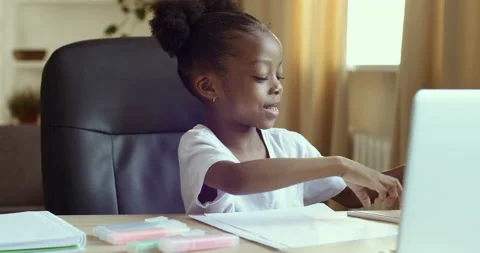 Curious preschool african mixed race girl using laptop on couch, little  smart black kid typing on computer chatting with friends online alone at  home, child security, children and gadget concept Stock Photo